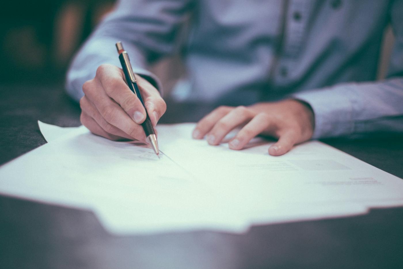 A hand marking a printed page during a document review.