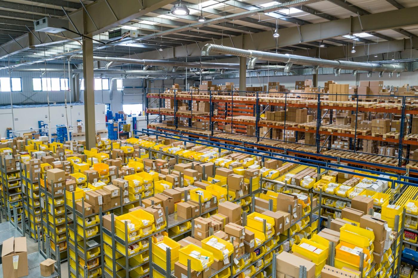 A fulfilment floor of stocked bins under a high industrial roof.